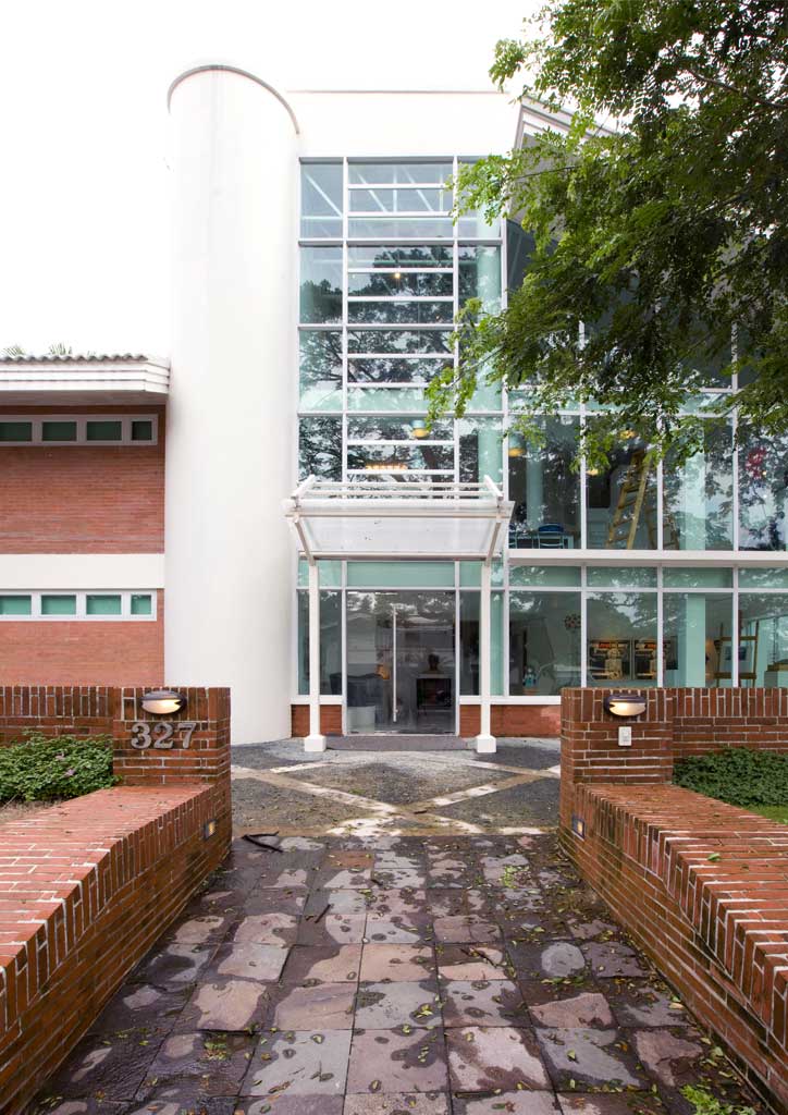 Street entrance to the ArtLab. The brick-faced planters and rooms to the left side were designed to blend into the main house, BrightHouse, which is to the right of ArtLab. On the other hand, the whitewashed and glass-clad main section devotes views of the lot's arboreal richness to the indoors--Jean-Marie being a nature lover as well.