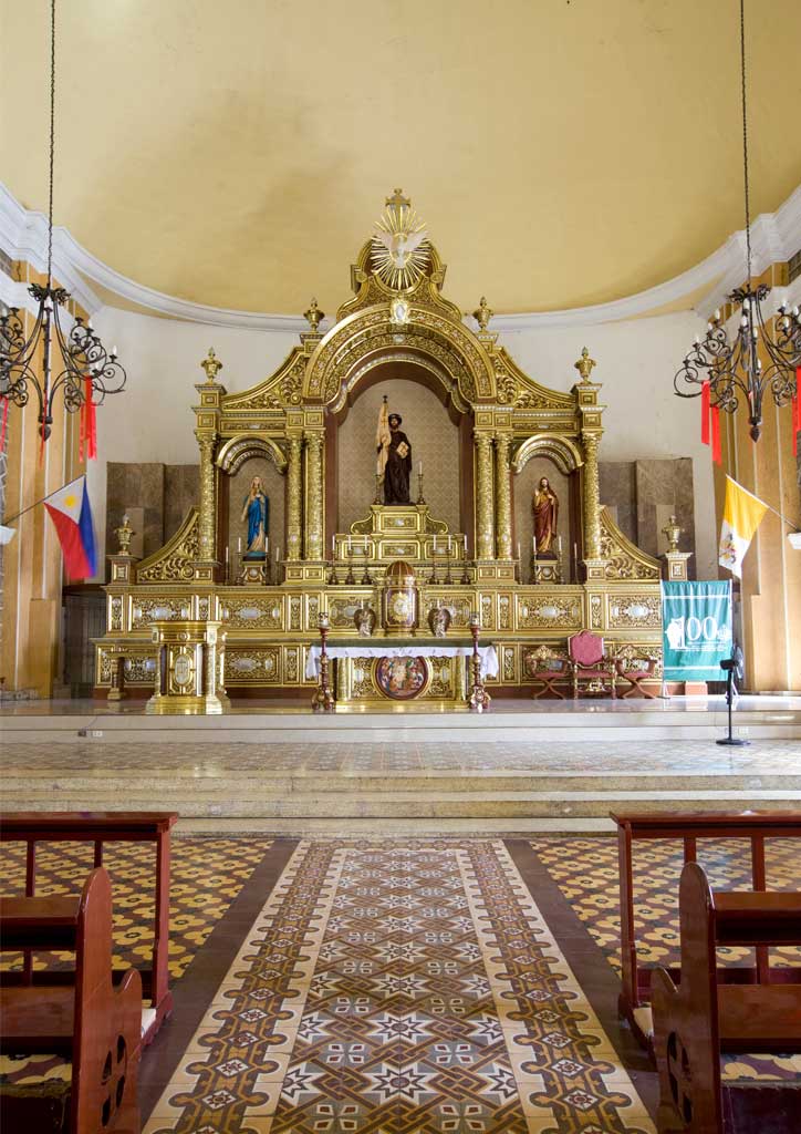 The gold altar of a Batangas church with machuca floor tiles.