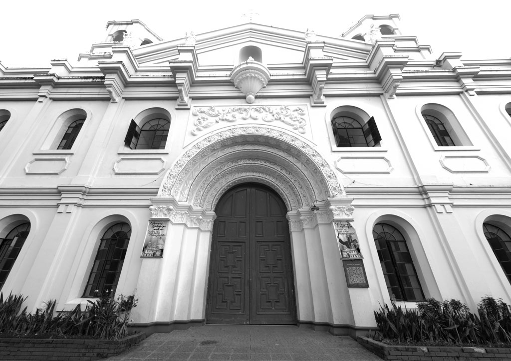 The exterior of a Batangas church with shafts topped by Corinthian capitals and Romanesque molded arches.