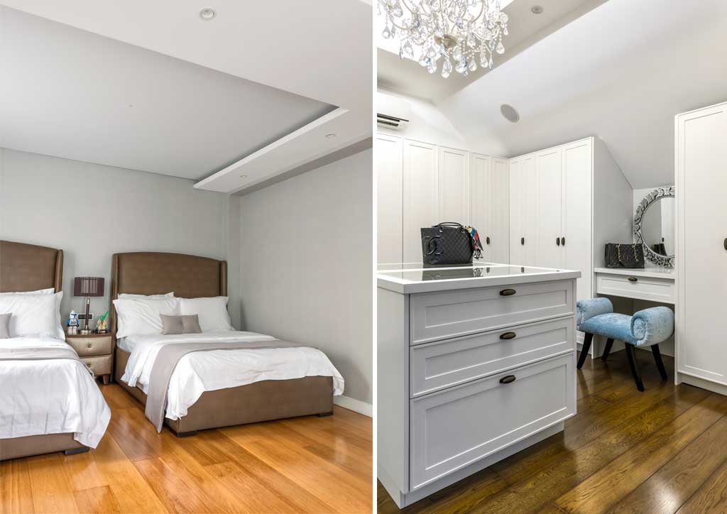 A lavish chandelier and plush circular rug serve to center off-white seating and a coffee table encrusted with mother-of- pearl in the high-ceilinged living area.