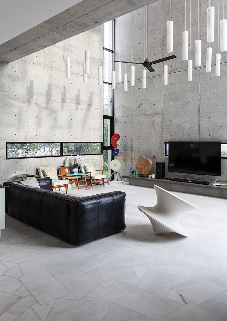 Seshan Design's interior of a modern two storey house design showing a living area with double height ceilings and modern chandelier.