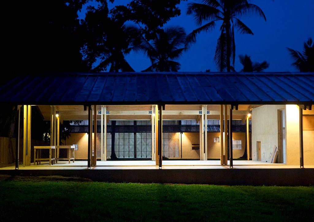 A modern wooden pavilion lit up at night.