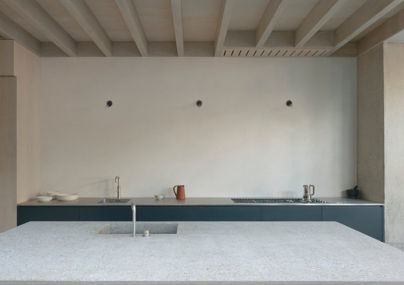 view of concrete kitchen island with sink