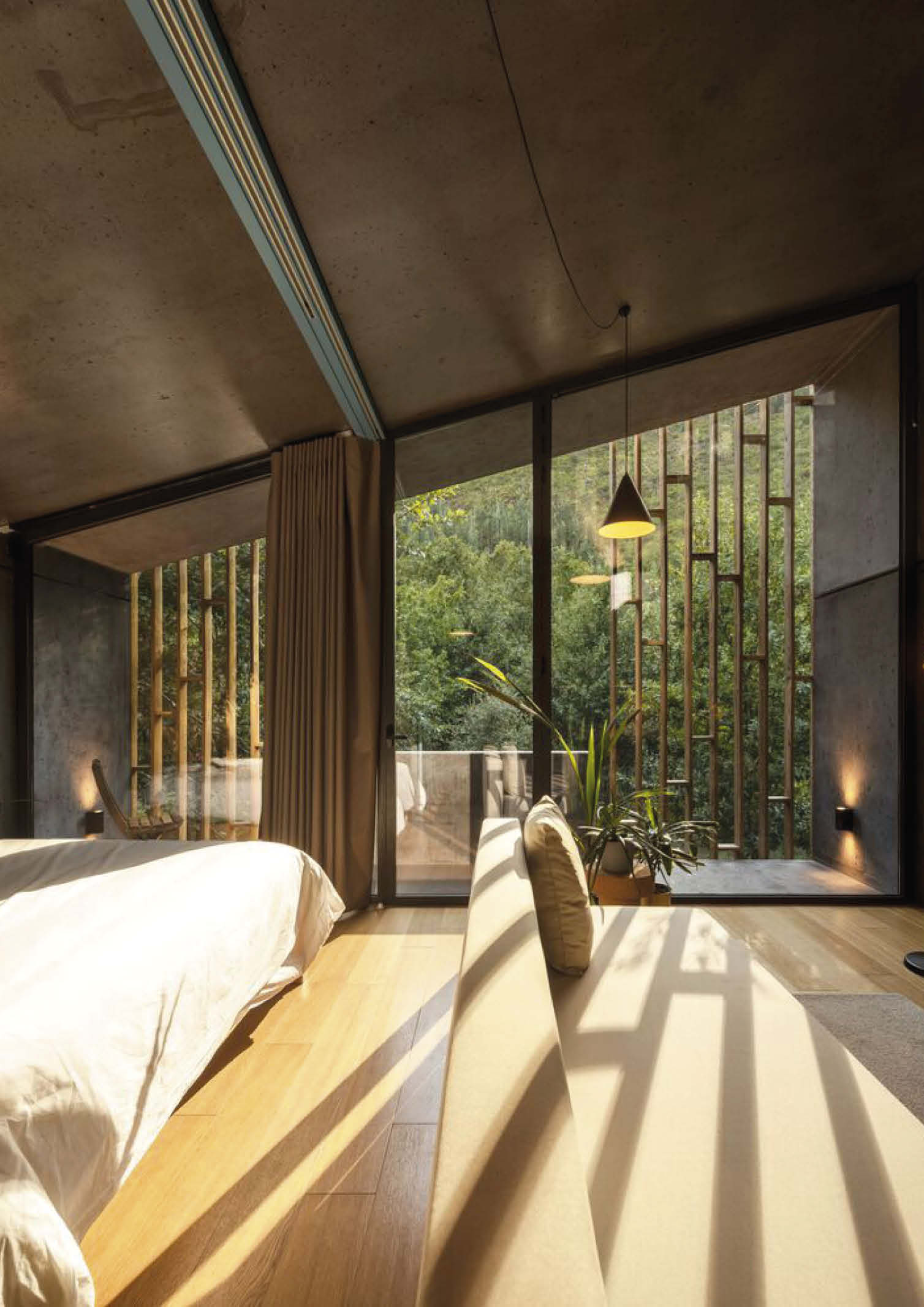 the interior of a prefab house with pitched roof,, bed and living area.