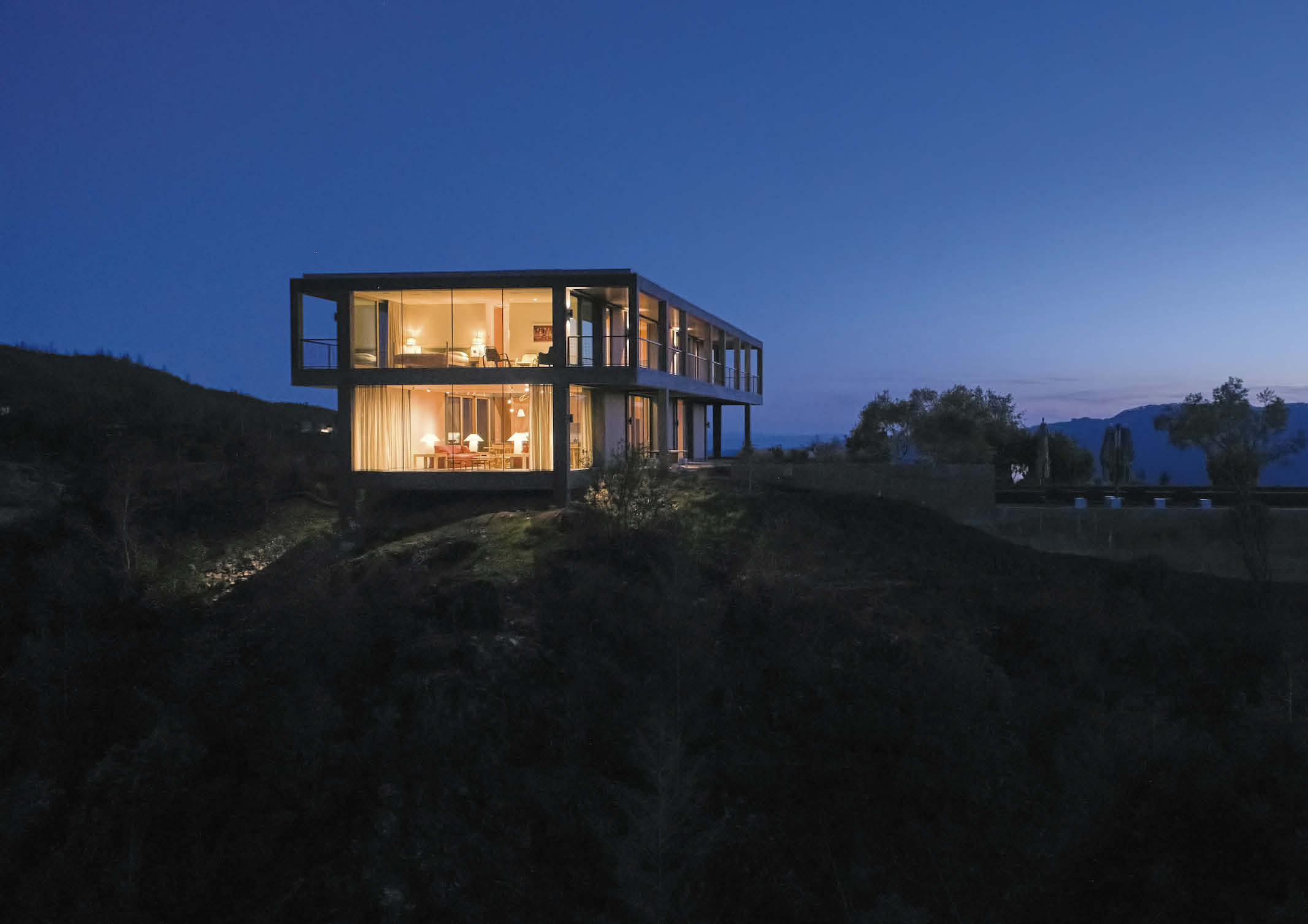 A modern two storey house design made of concrete and wooden accents featuring a grid system.