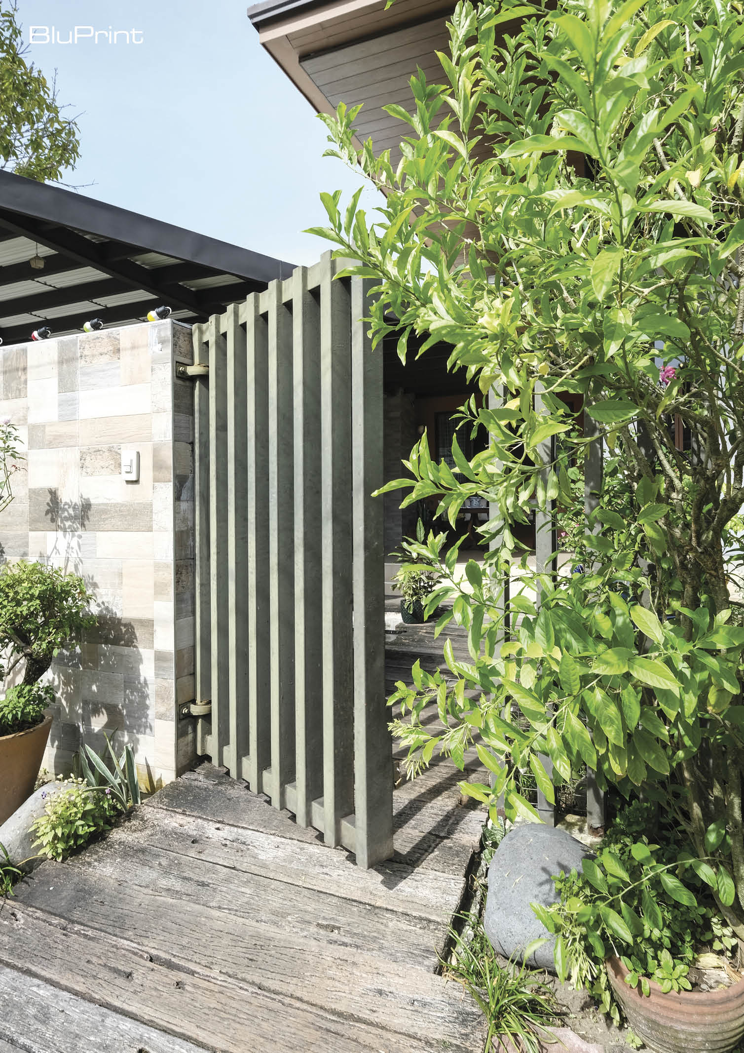 Detail of a modern pedestrian metal gate surrounded by greenery