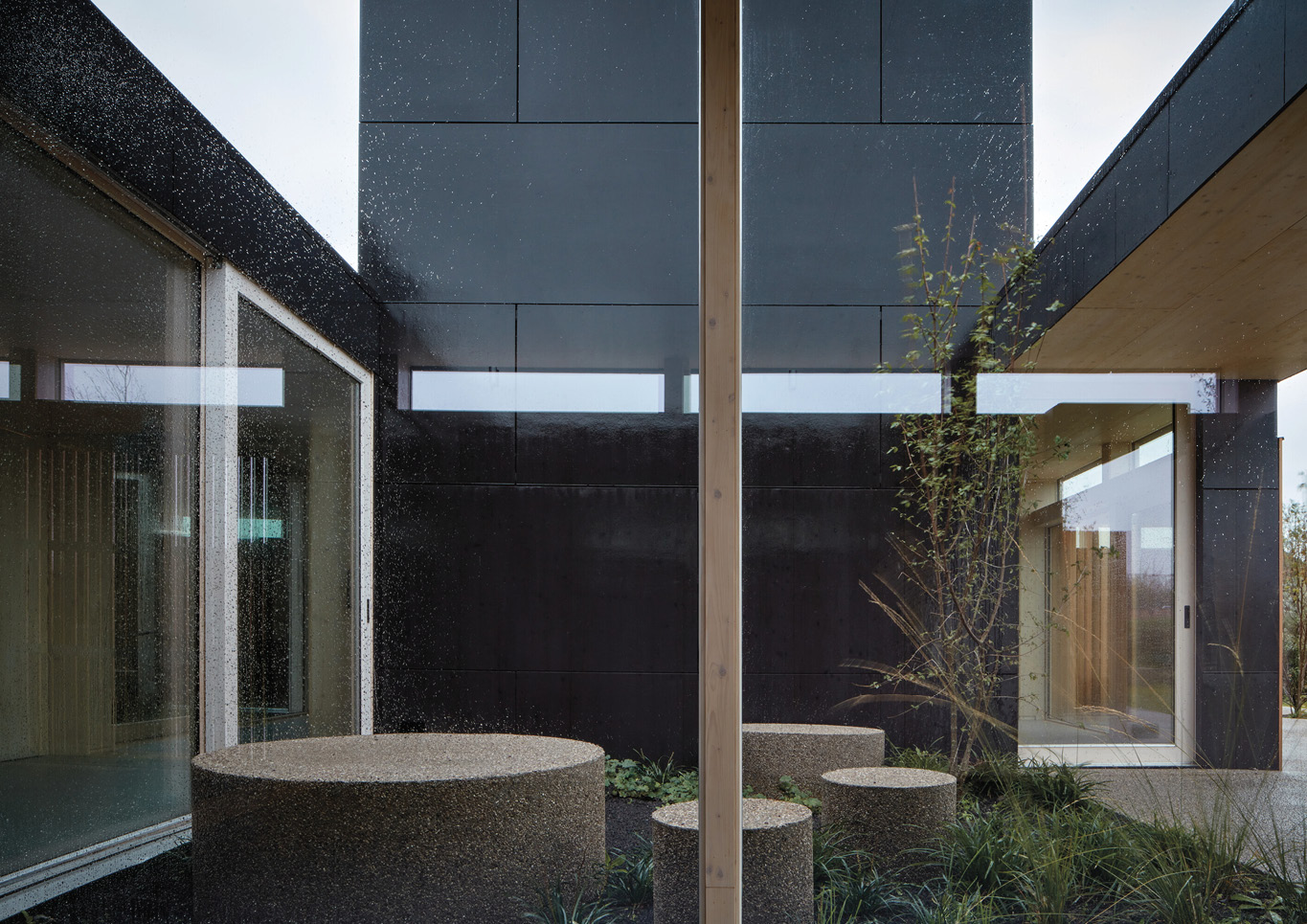 Outdoor area with round outdoor seating next to trees in Warm Nest, a Maggie care facility.