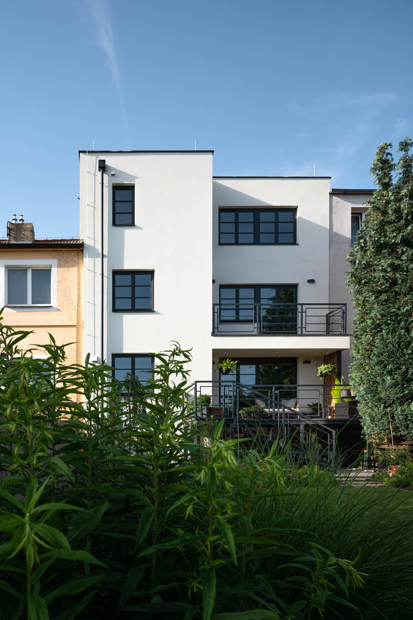 In a Row is a three-story family house surrounded by a garden.