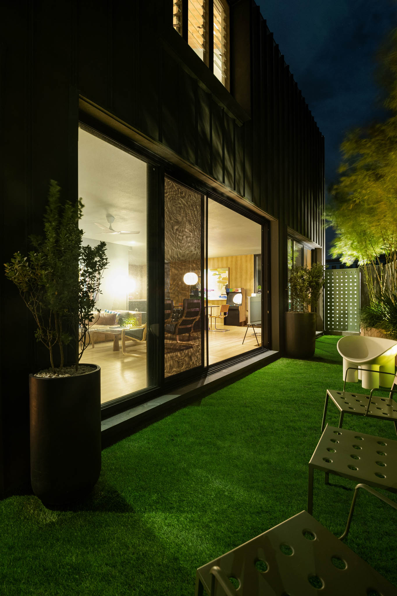 View of the garden in the evening with bamboo poles and tropical plants.