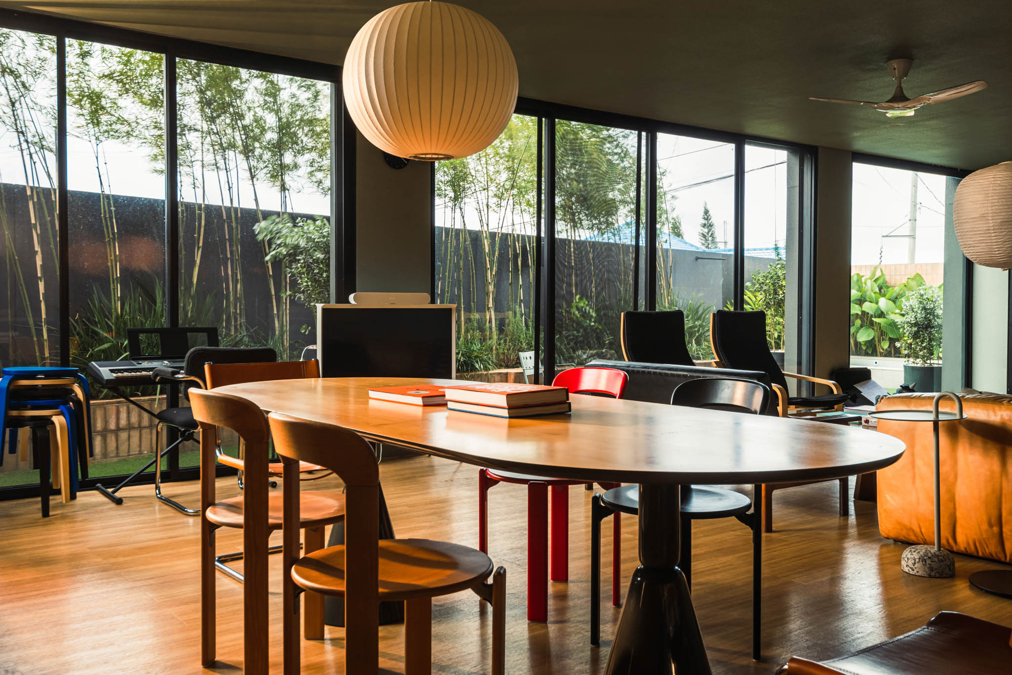 R House's dining area featuring an eclectic collection of chairs looking out into the garden.