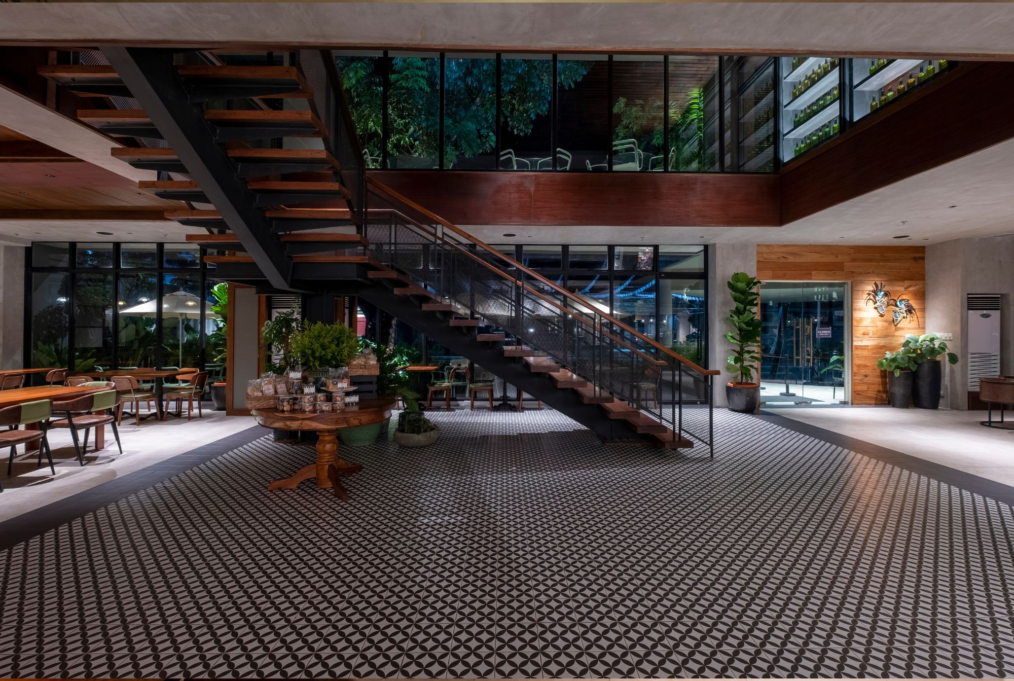 The central staircase in a wide open space at Cafe Bobs designed by Larawan Ink, with wooden treads and metal balustrade.