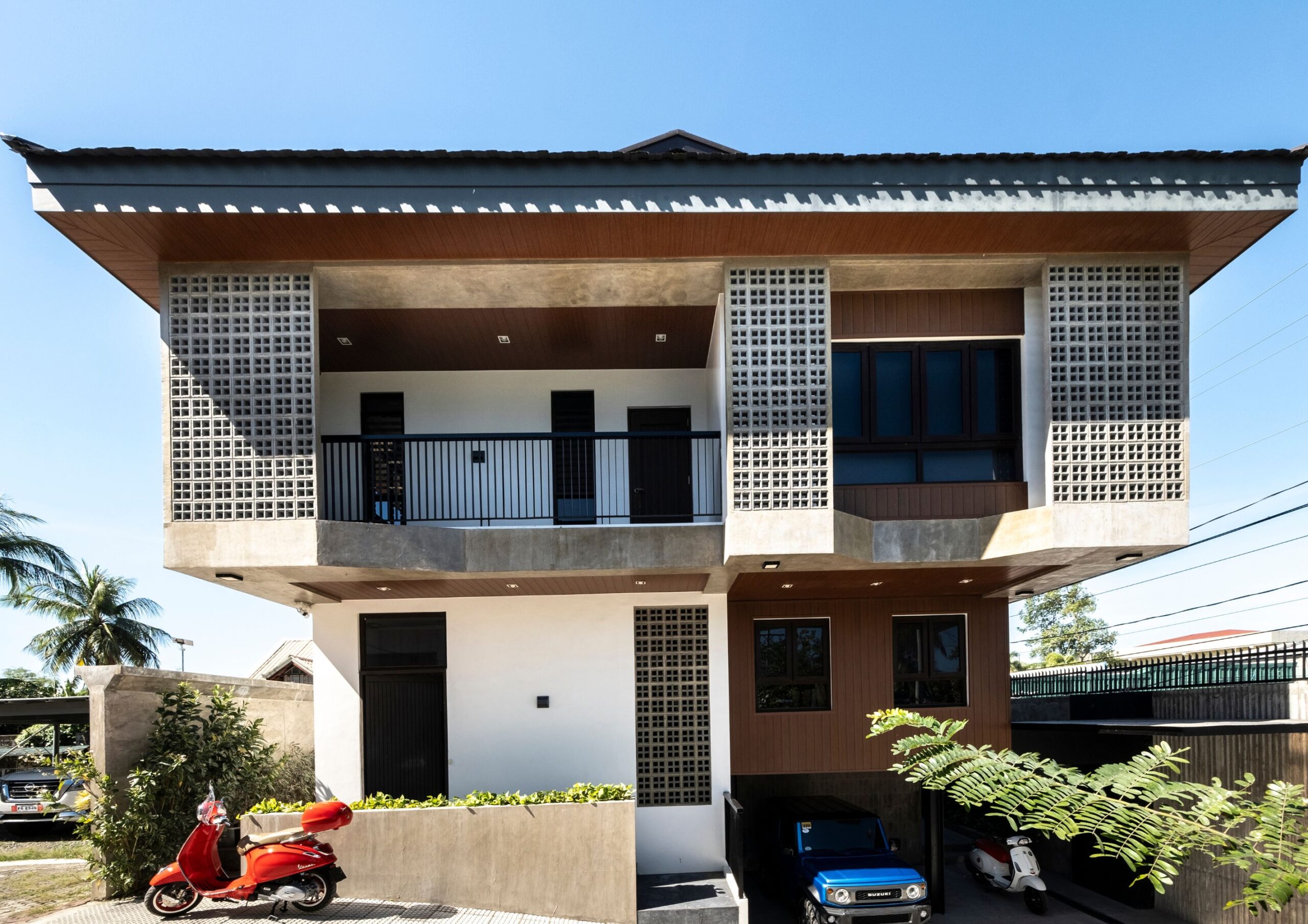 the front elevation of Tabing Bahay, a modern 2 level bahay na bato with underground garage, a dutch roof and concrete screens.