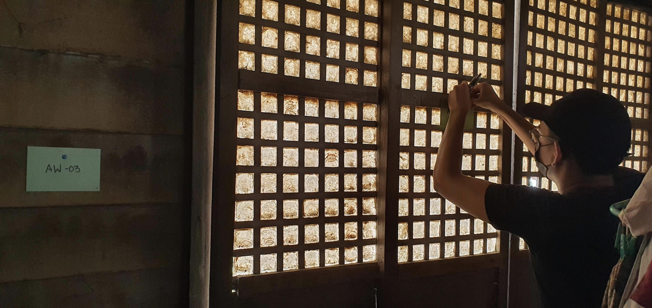 A worker restores a bahay na bato's capiz windows.