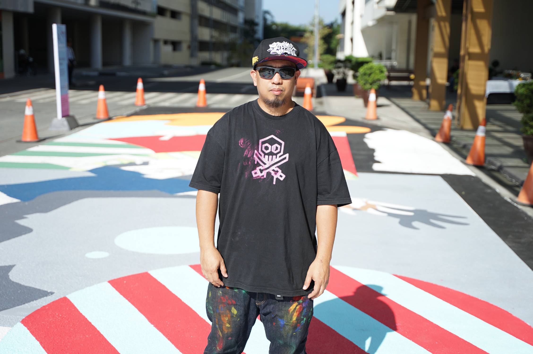 Trip63 standing in front of "Stance" mural. Source: The Art House.