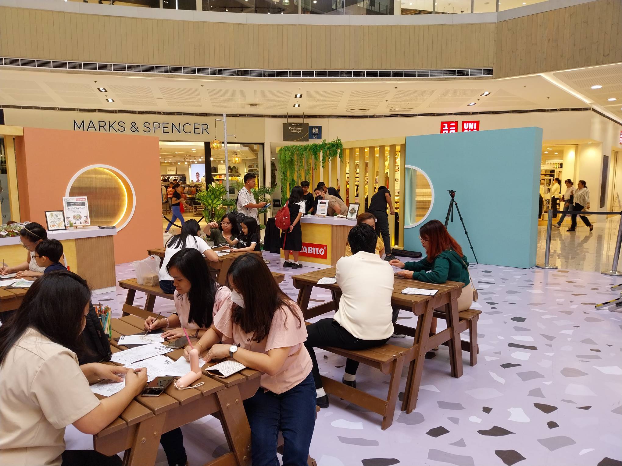 Families and mallgoers drawing at tables provided by Stabilo. Photo by Elle Yap.