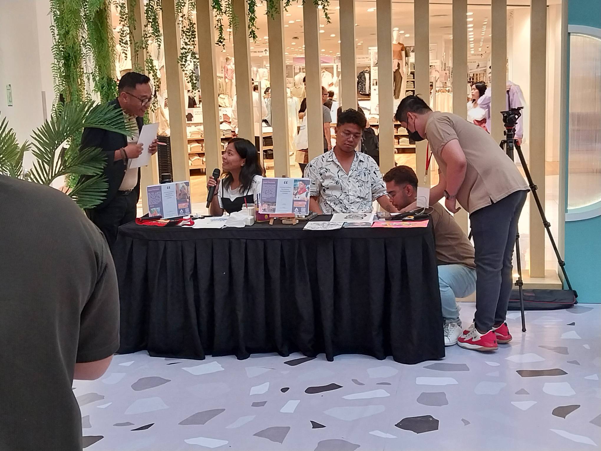 One of the artists explaining their work to the host. Photo by Elle Yap.