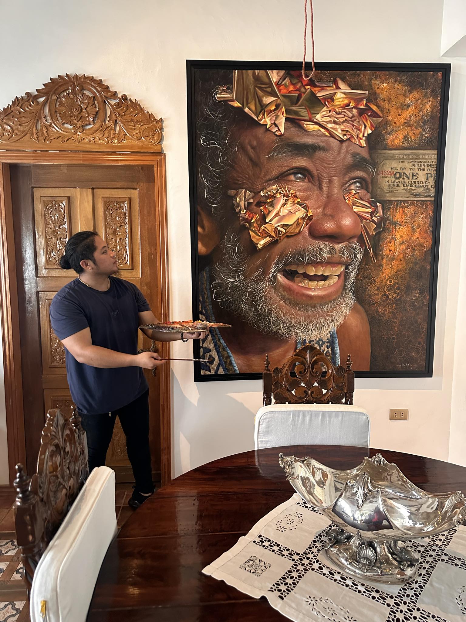 The artist posing in front of their work. Photo by Elvin Vitor.