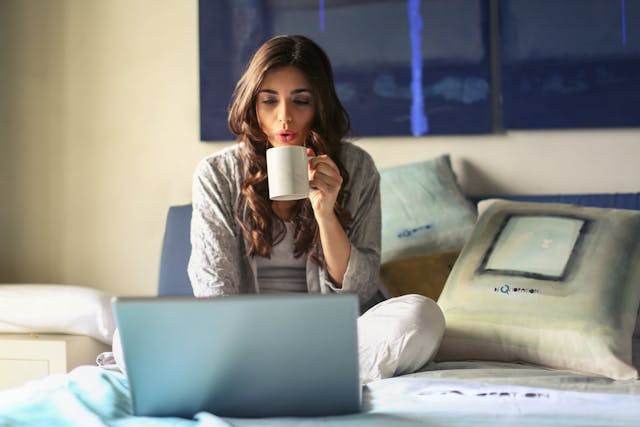 A woman working on her bed. Photo by Andrea Piacquadio. Source: Pexels.