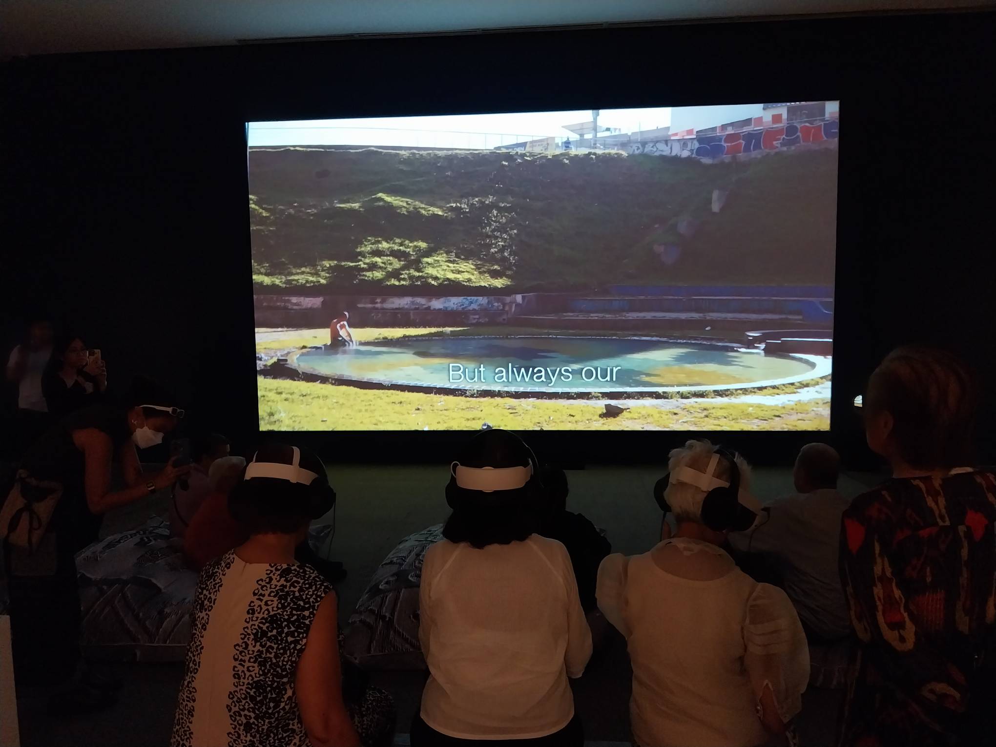 Three spectators using the VR component of the exhibit. Photo by Elle Yap.