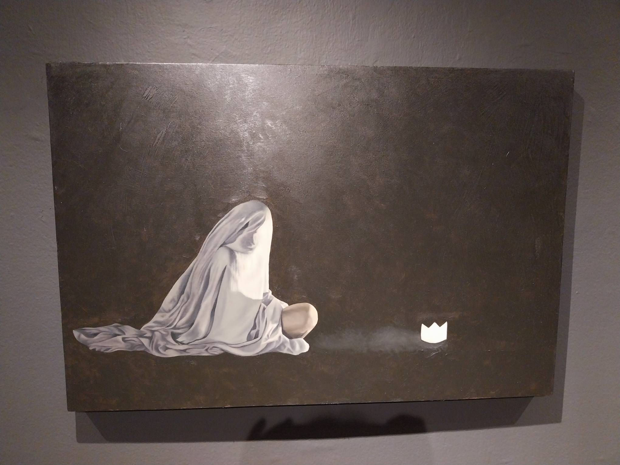 A figure sitting down while looking at a crown out of reach. Photo by Elle Yap.