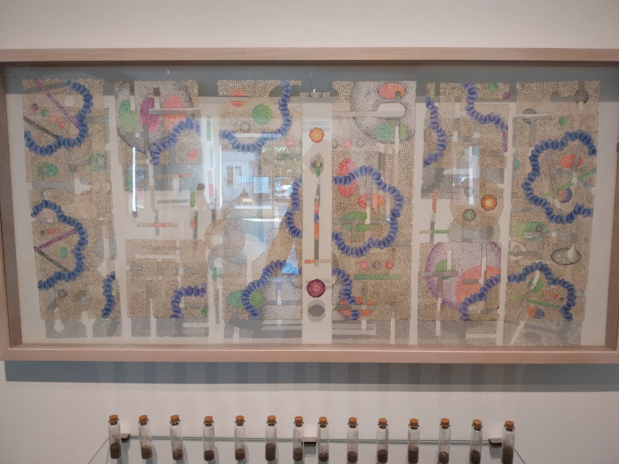 Close-up of the works with the tiny jars of ashes underneath. Photo by Elle Yap.