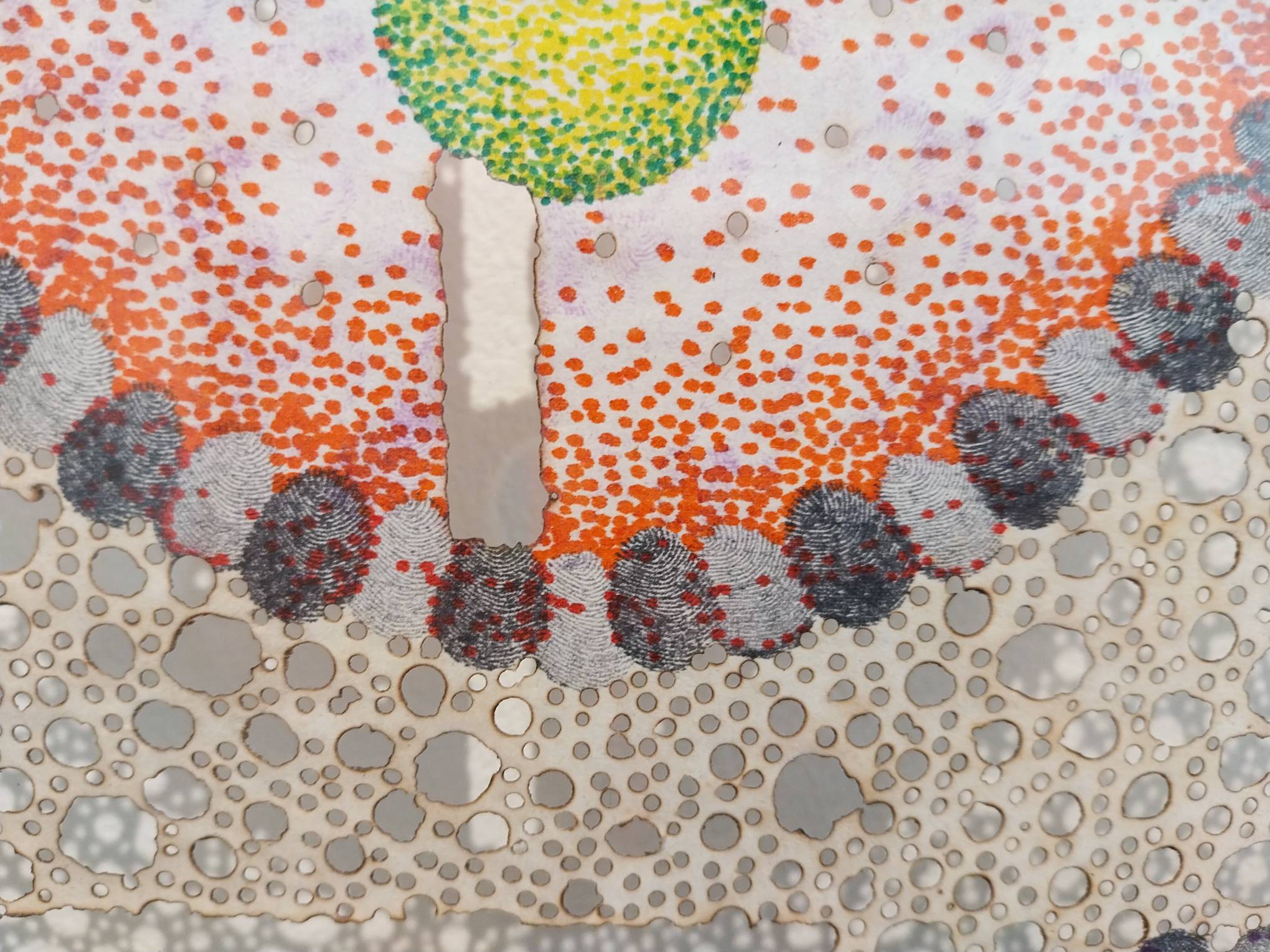 Black fingerprints next to orange and green dots. Photo by Elle Yap.