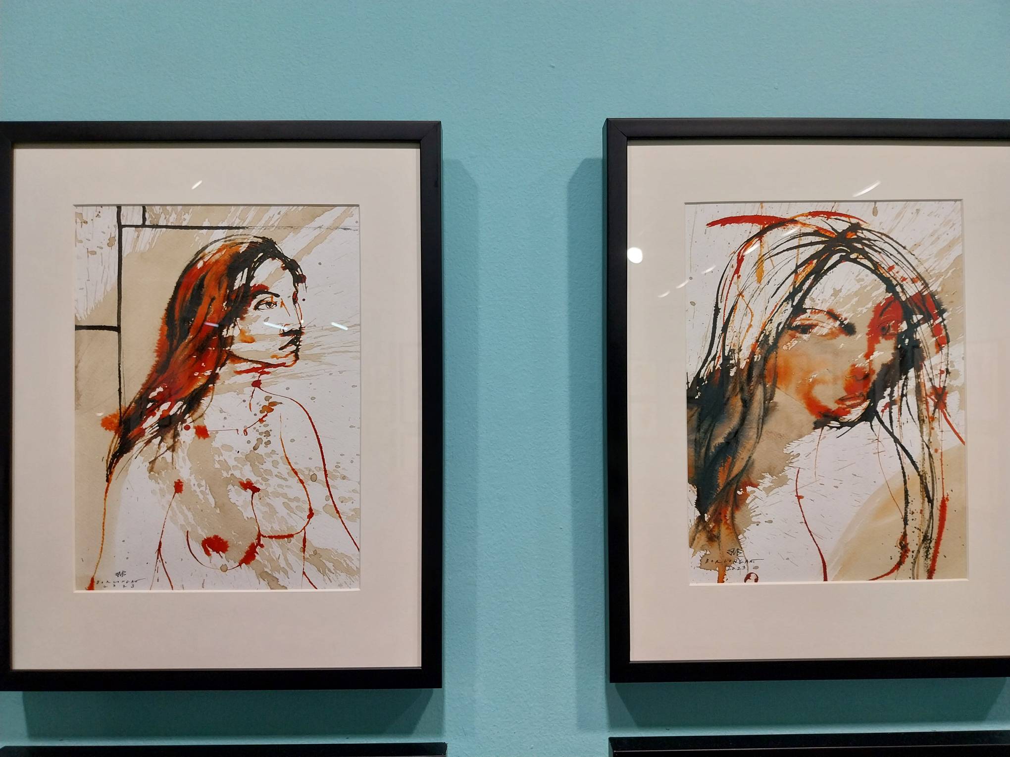 Two paintings by Elmer Borlongan with one woman looking at another judgmentally. Photo by Elle Yap.