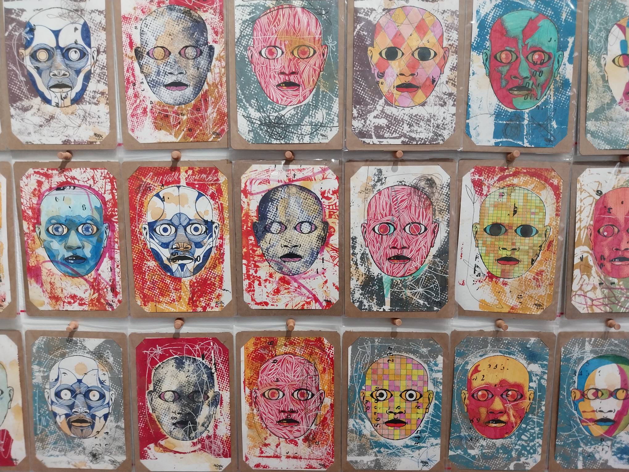 Close-up on wall of faces. Photo by Elle Yap.