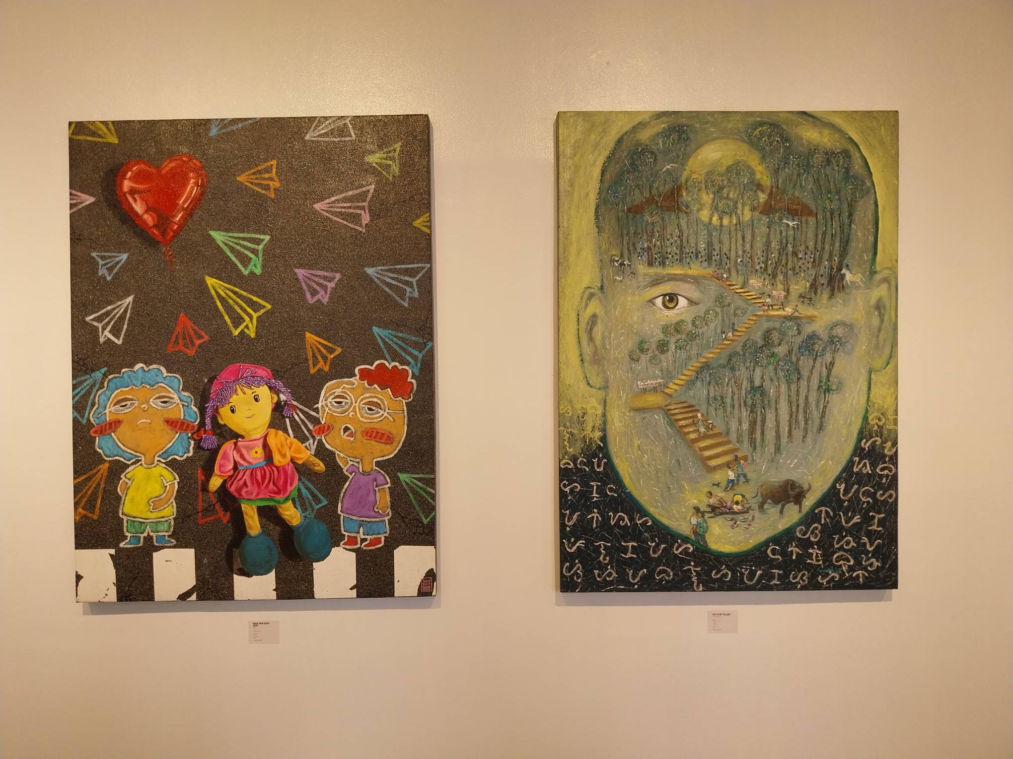 "Life in my Village" by Henri Cainglet (right) and "WH3R3 YOUR H34RT GO35" by Yoyo. Photo by Elle Yap.