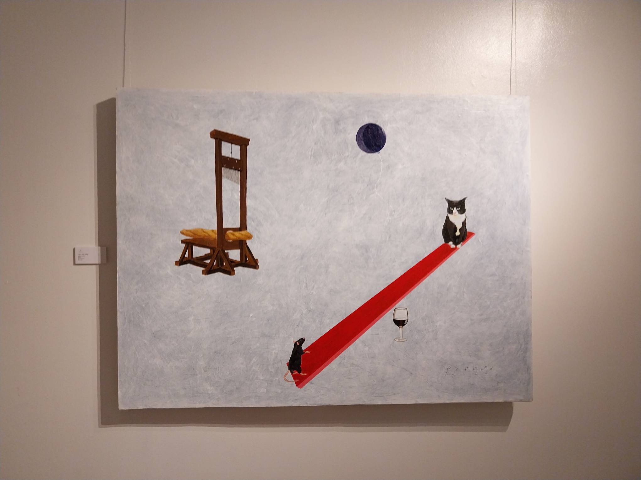 A painting with a cat, mouse, and guillotine. Photo by Elle Yap. 