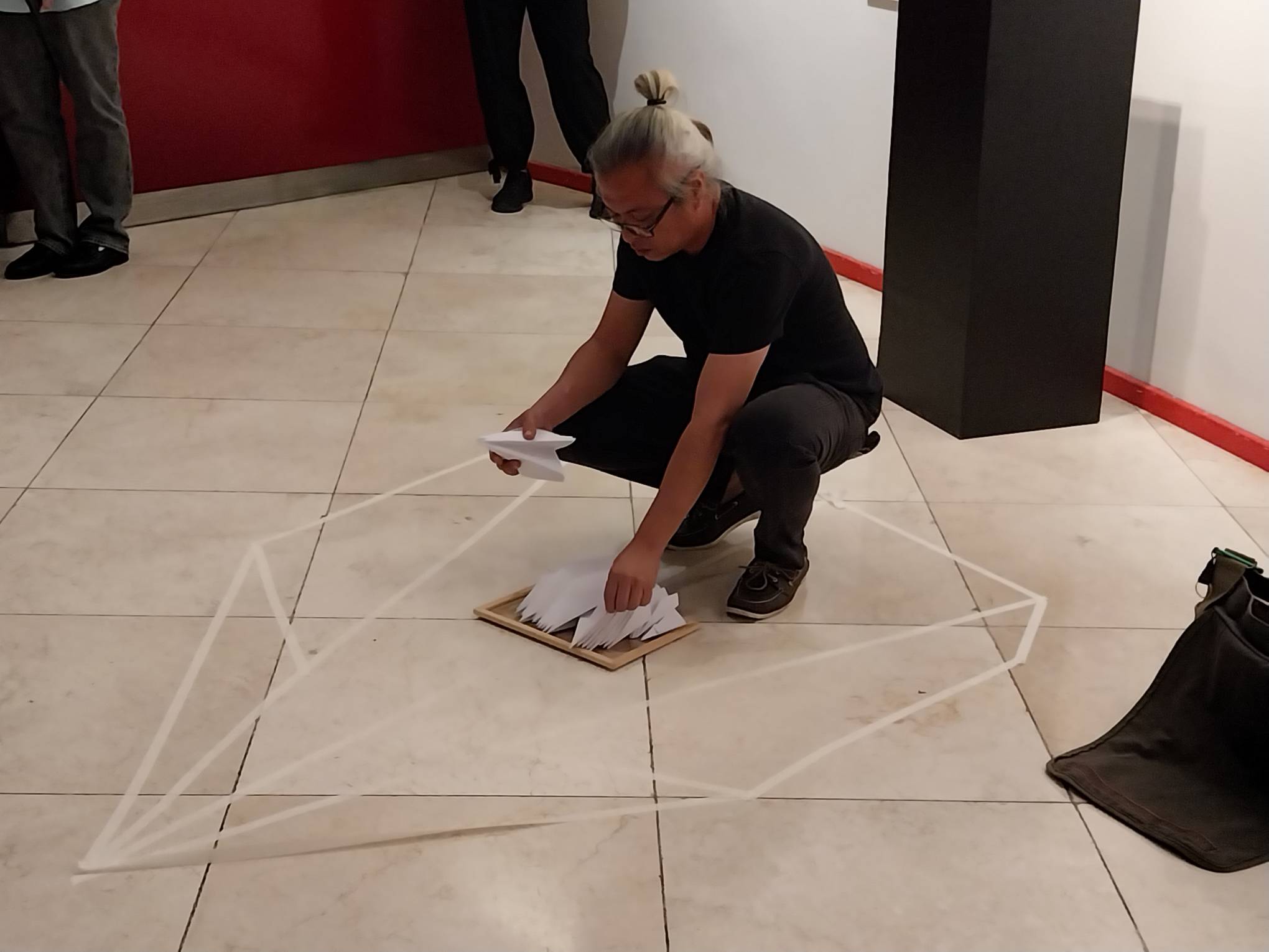The artist crafting an airplane with tape. Photo by Elle Yap.