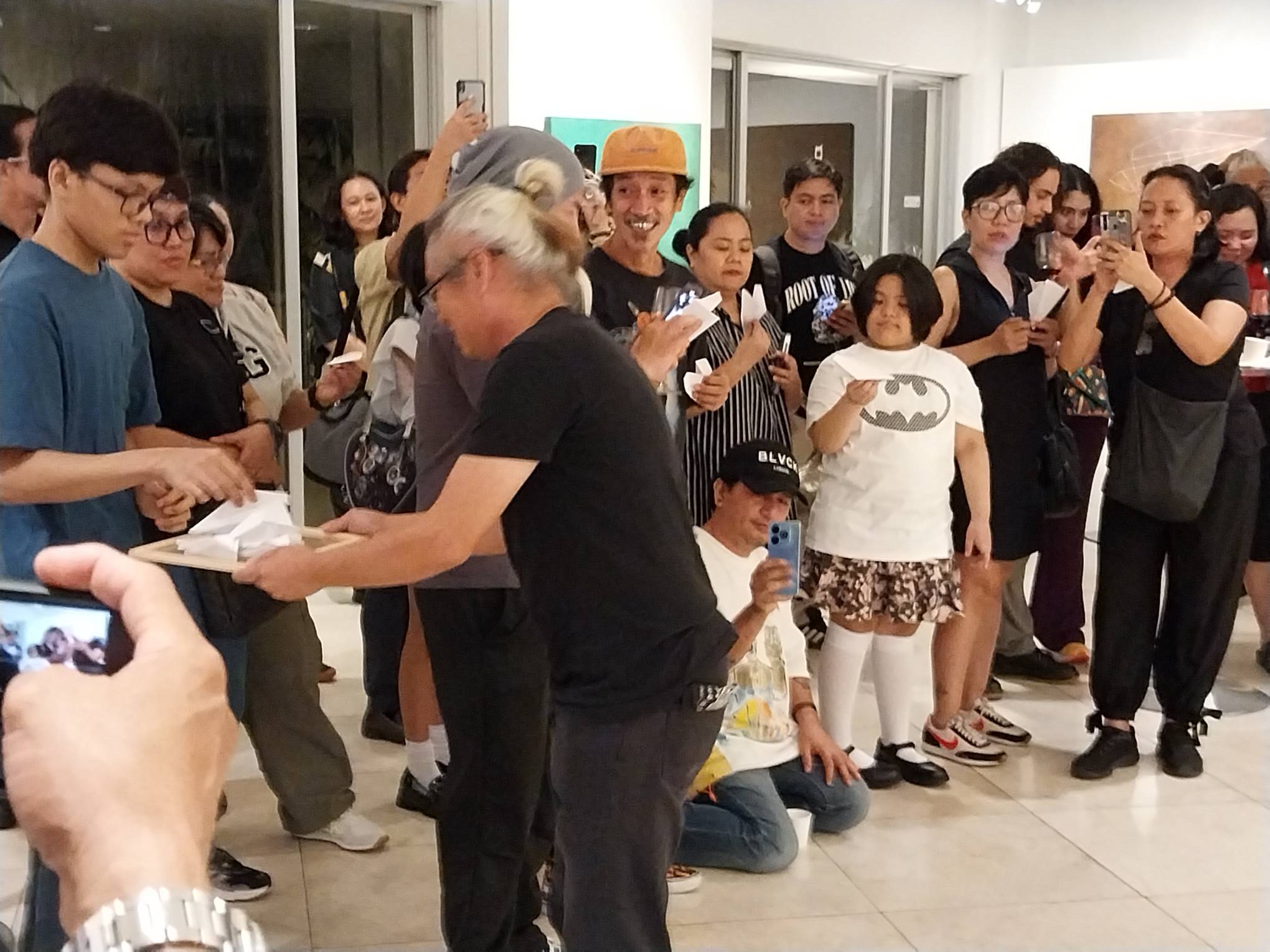 For the performance art, Jethro Jocson gives away paper airplanes. Photo by Elle Yap.