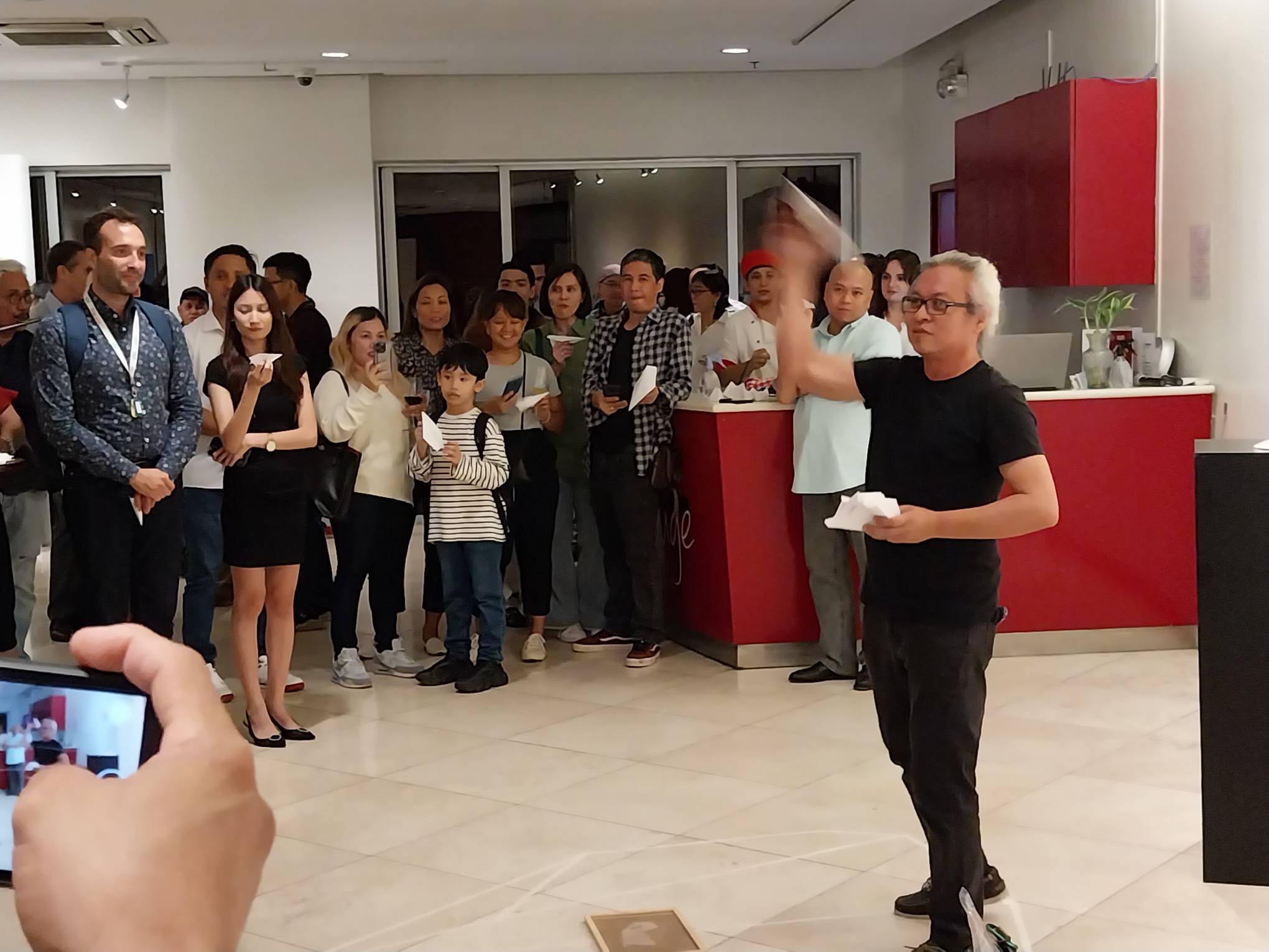 The artist throwing a paper airplane. Photo by Elle Yap.
