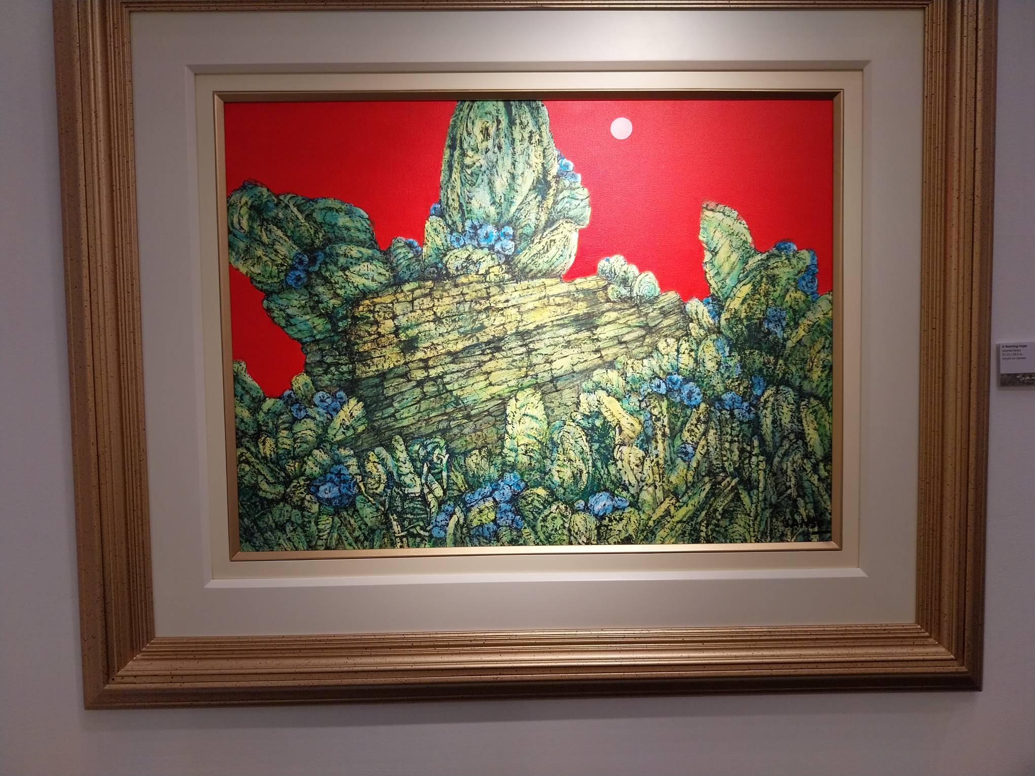 Painting of a rock and cactus with a red background. Photo by Elle Yap.