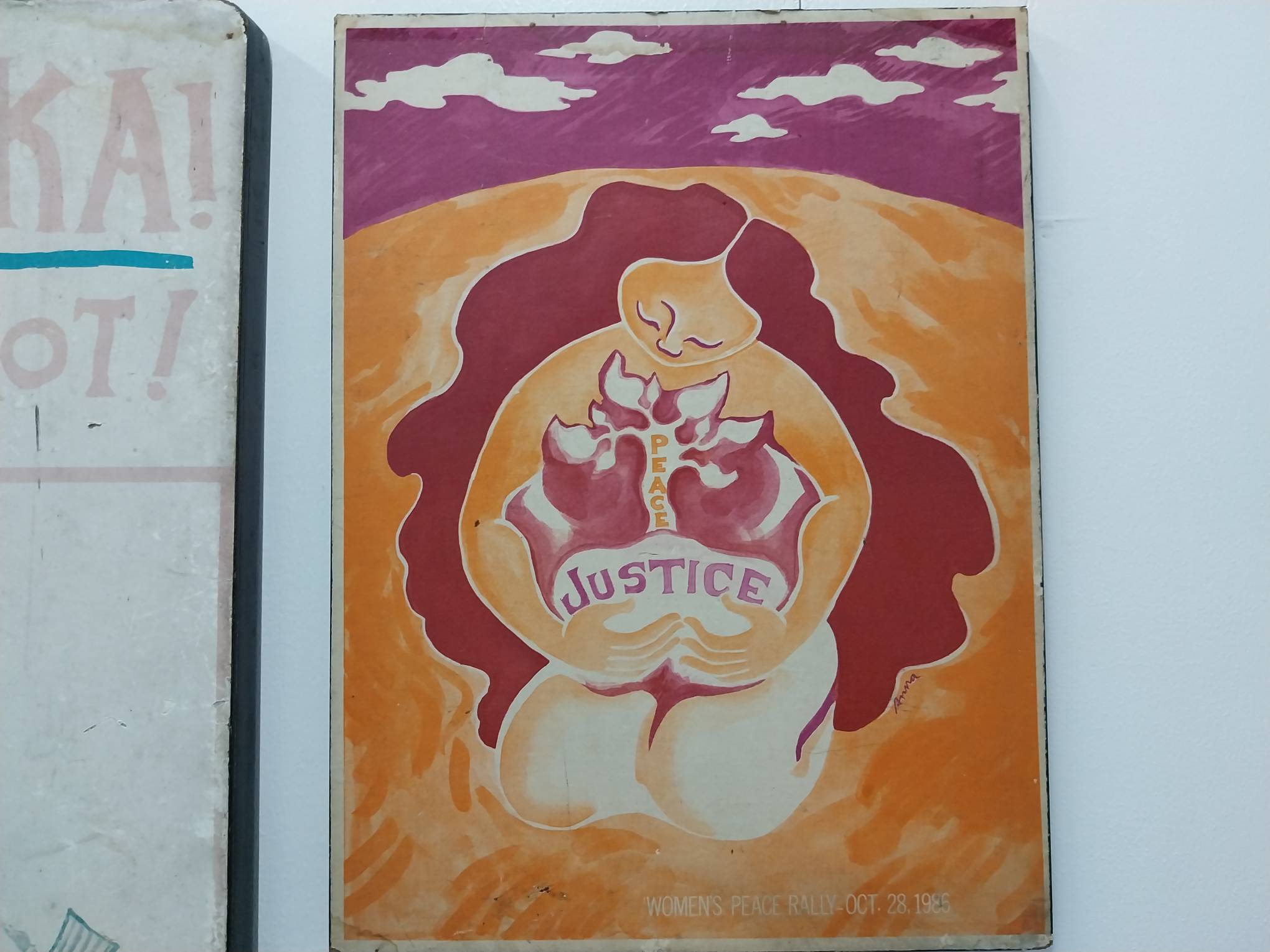 A painting of a woman hugging a flower saying "Justice" and "Peace." Photo by Elle Yap.