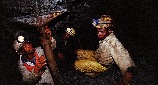 Two workers in a South African mine. Photo by FIFTY. Source: Wikimedia Commons.
