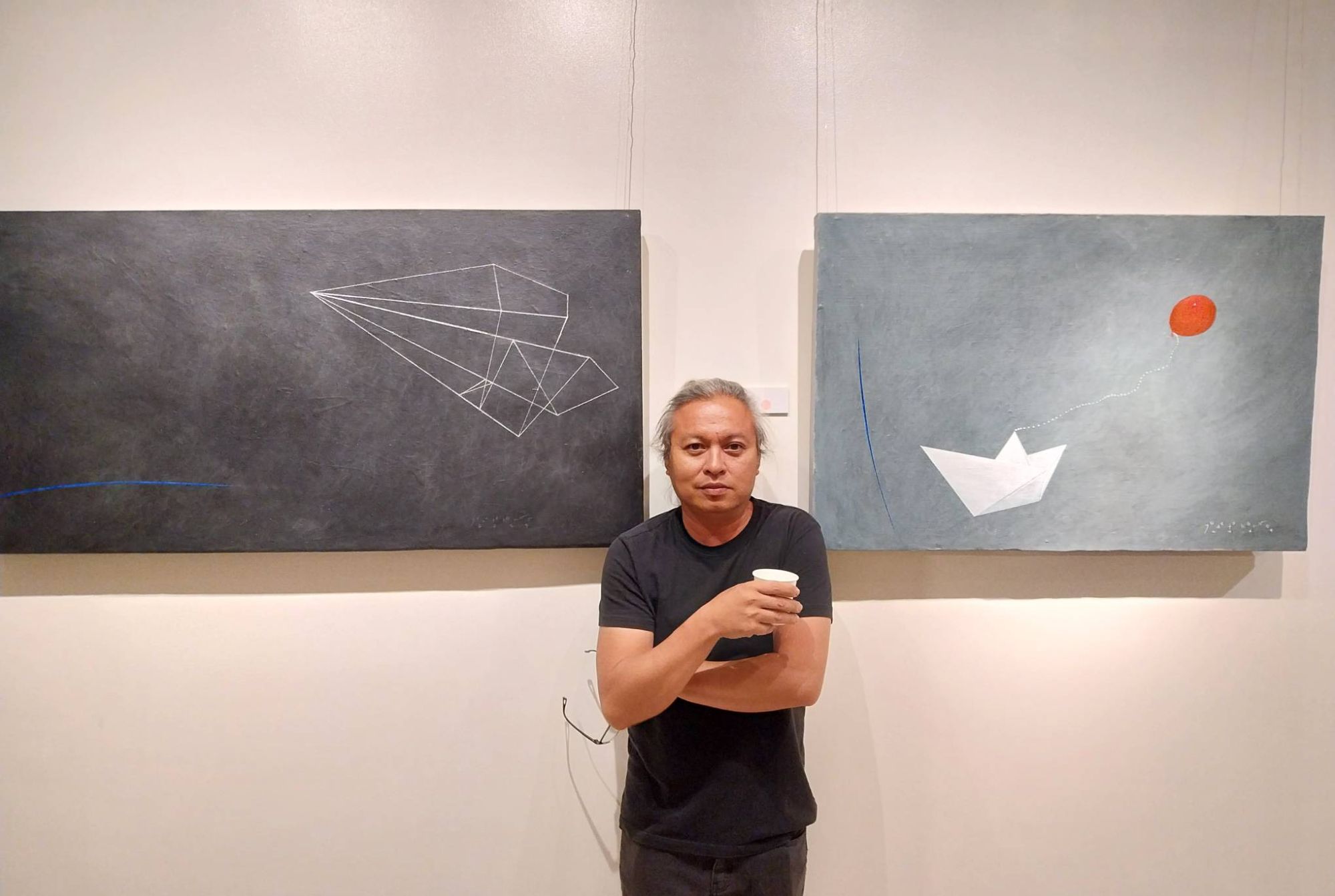 Jethro Jocson posing with two of their paintings for 