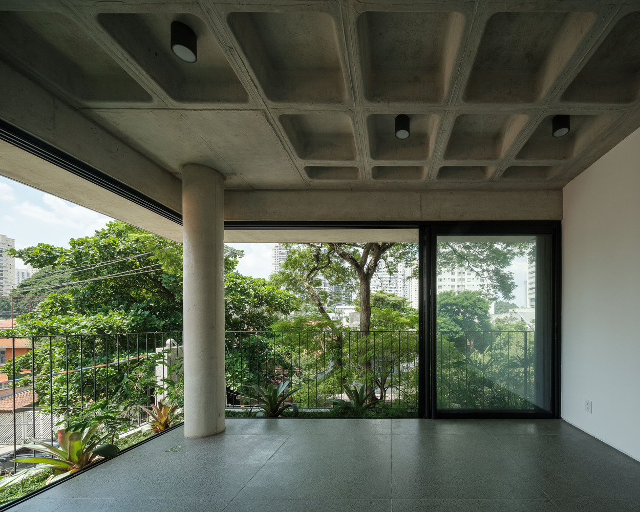 An empty room with the windows open. Photo by Pedro Kok and Rafael Fiorotto.