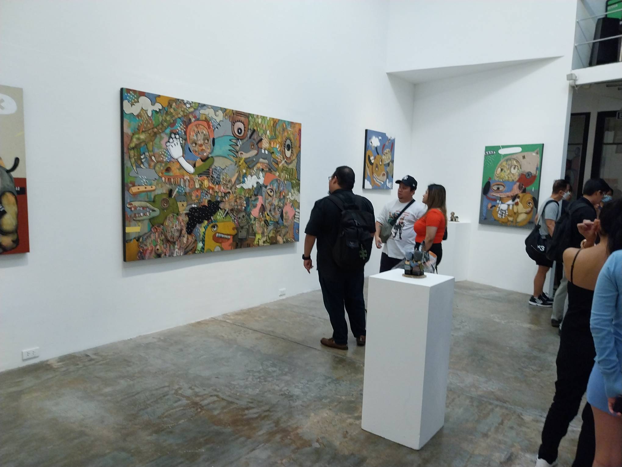 A gallery viewer observing a work by Reen Barrera. Photo by Elle Yap.