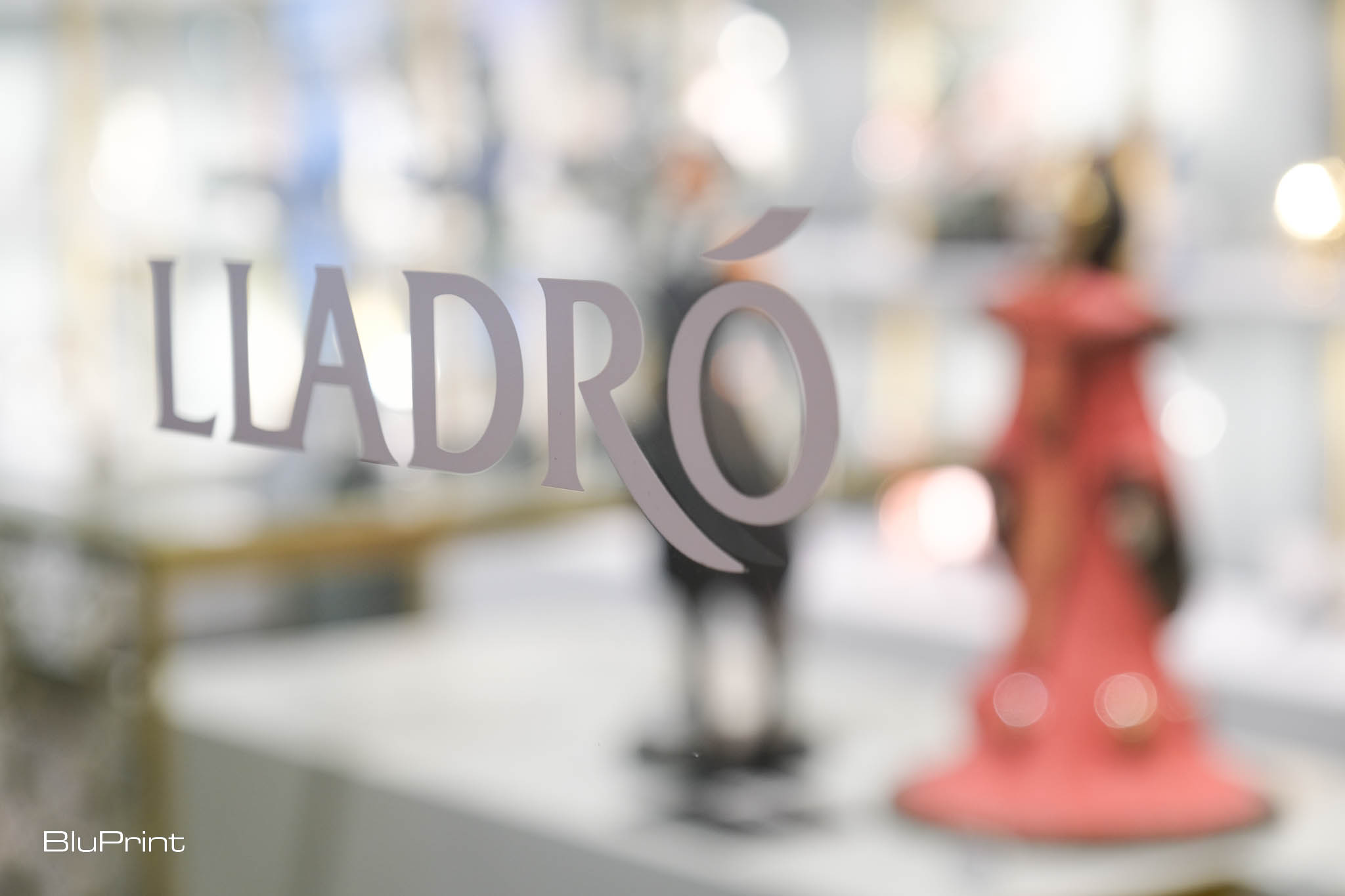 The Lladro logo on a pane of glass.