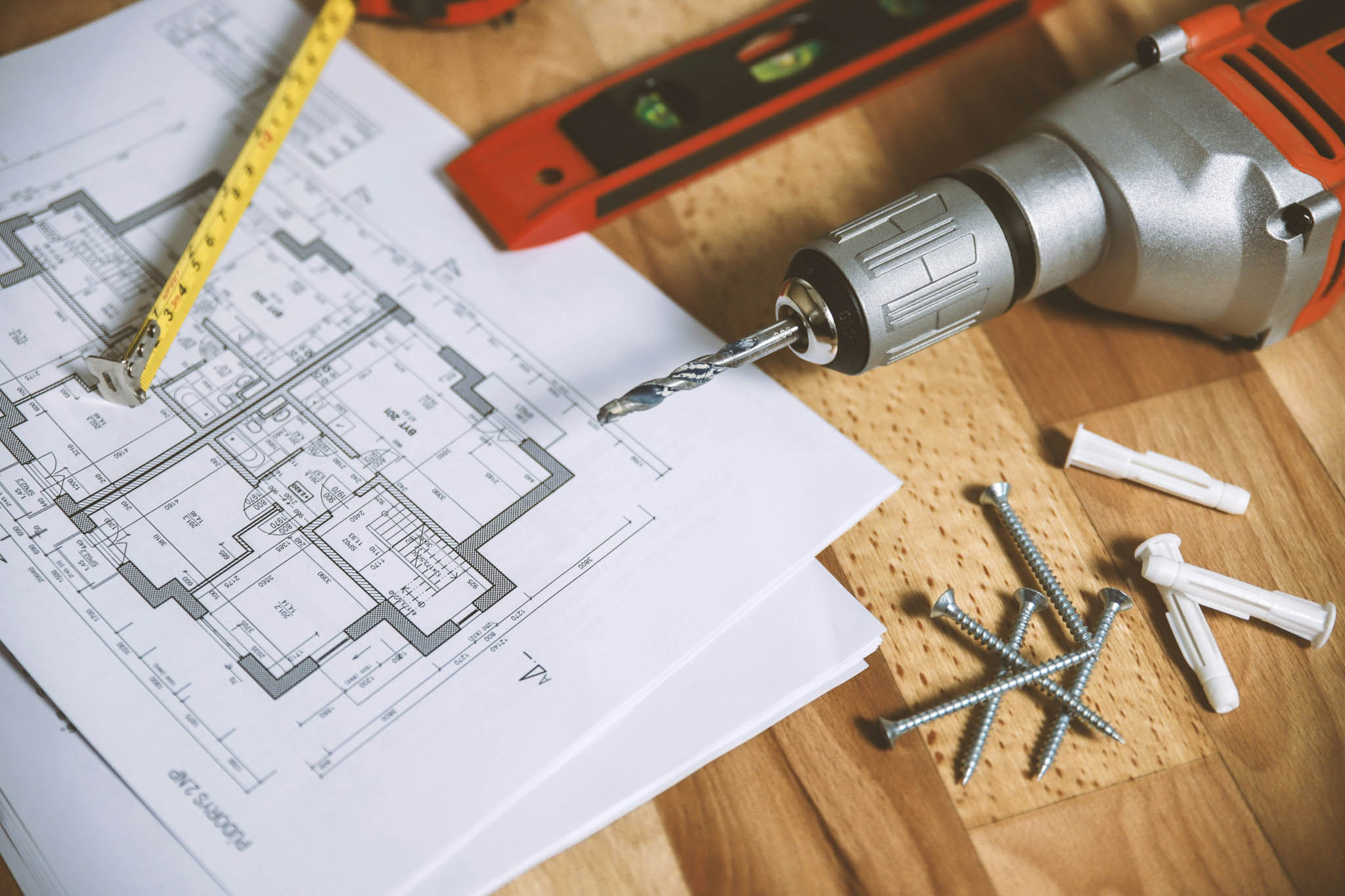 Renovation plans and tools on a piece of wood.