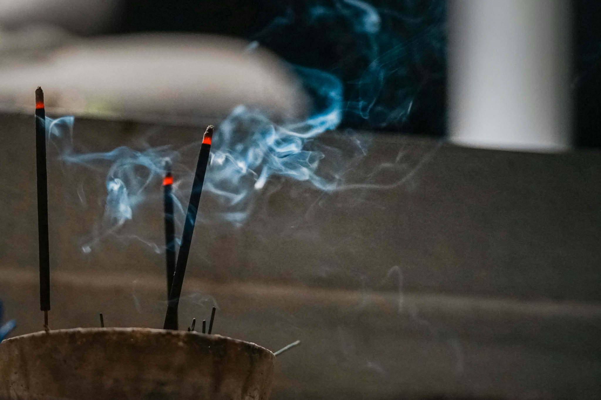 Incense burning and emitting smoke.