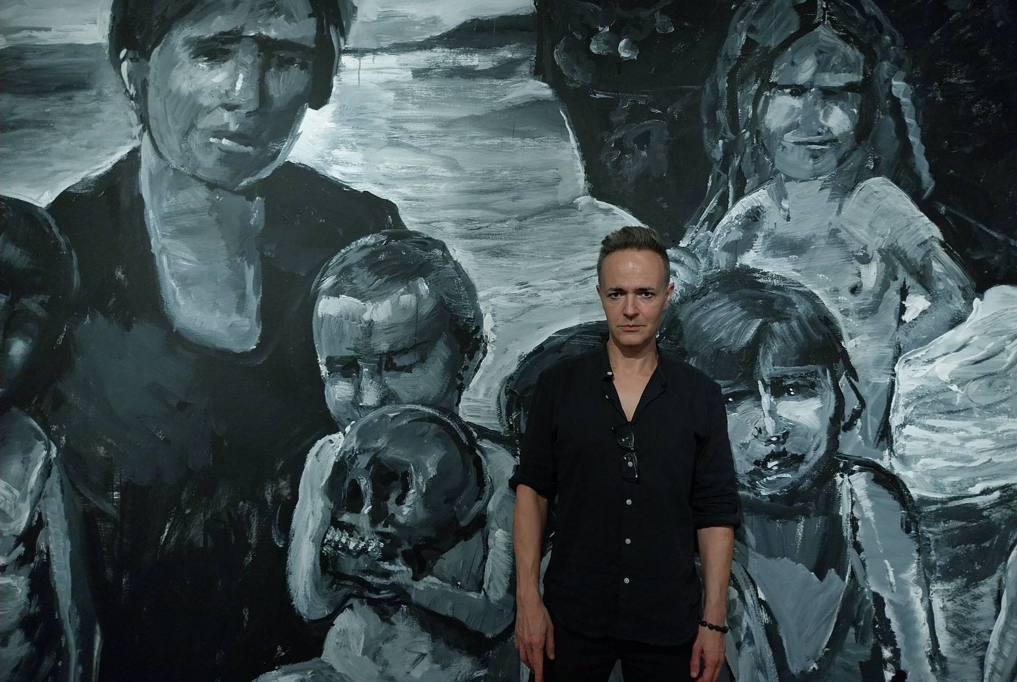 Artist Enrique Marty poses in front of a mural he made specifically for 