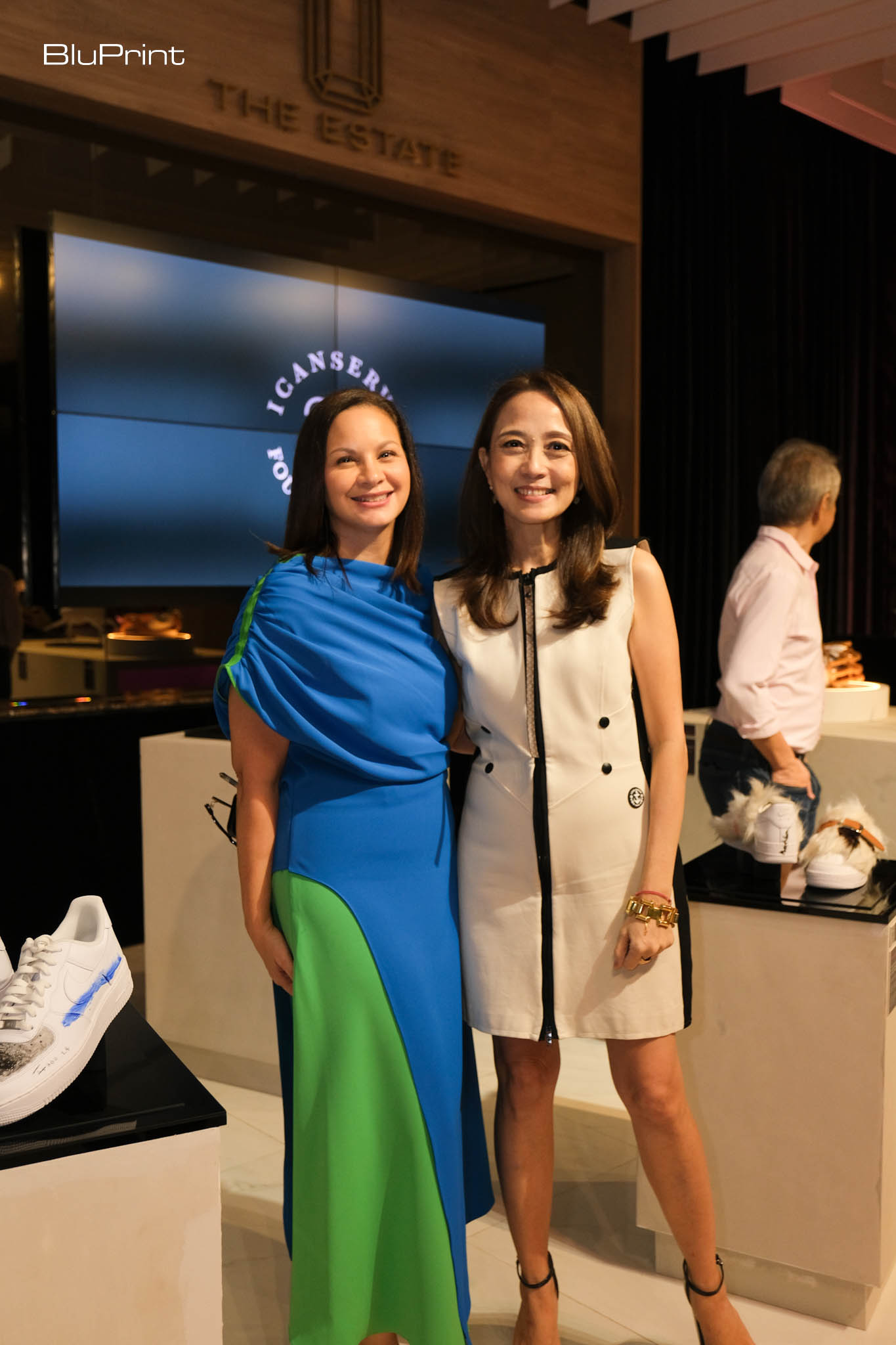 Two women, who are ICanServe Foundation's founding president and current chair, standing in an exhibit.