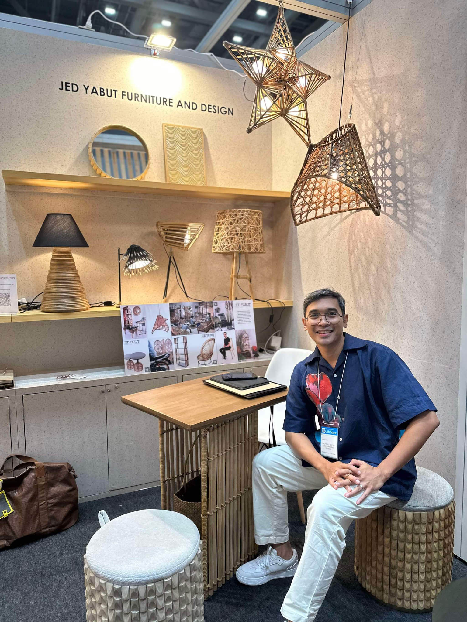 Jed Yabut sitting on a stool at Jed Yabut Furniture and Design's booth at Tokyo International Gift Show.