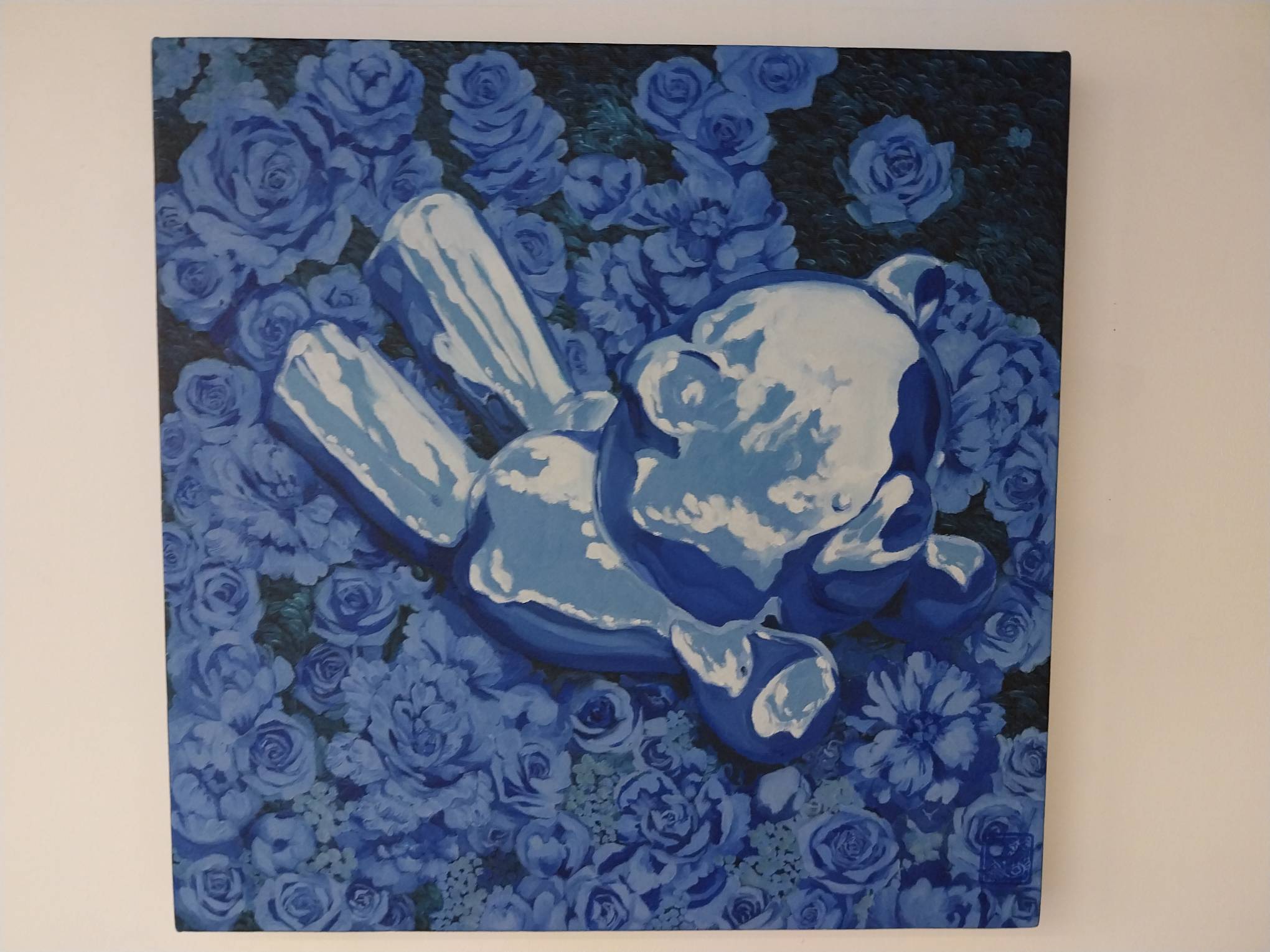 A metallic teddy bear lying in a flower bed. Made by Patty Py, exhibited at White Walls Gallery.