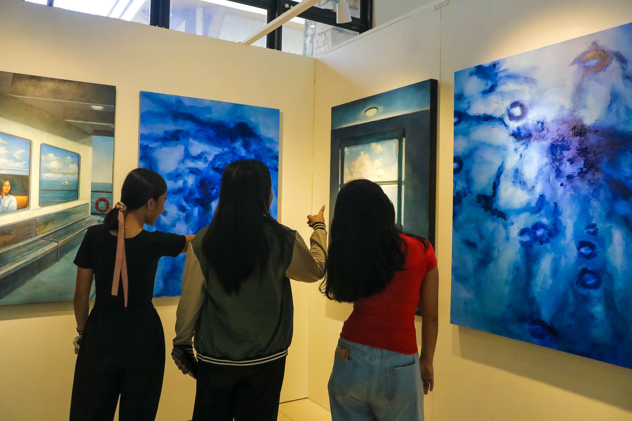Three people appreciating an artwork.