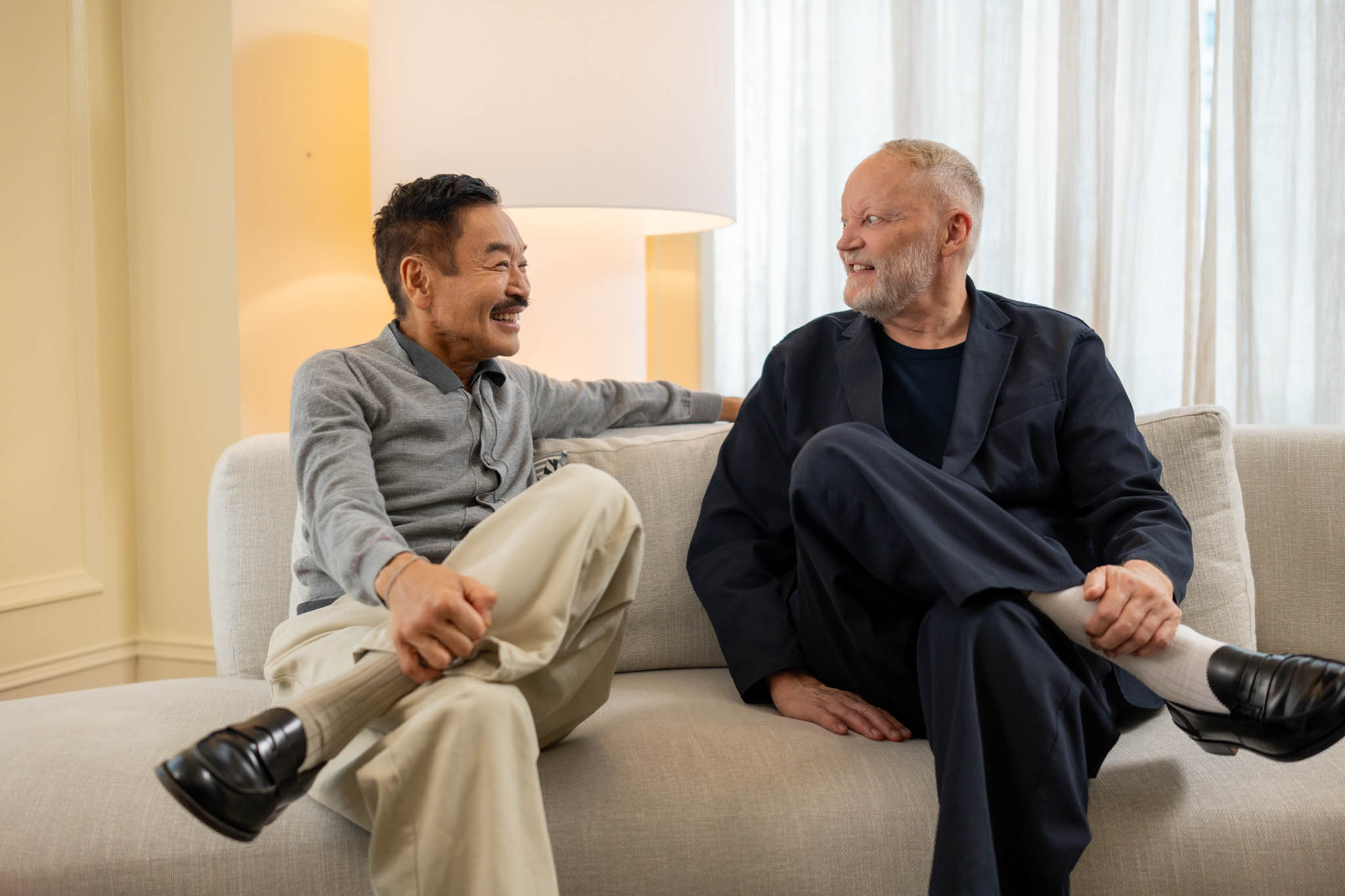 Designers George Yabu and Glenn Pushelberg sitting on a couch.
