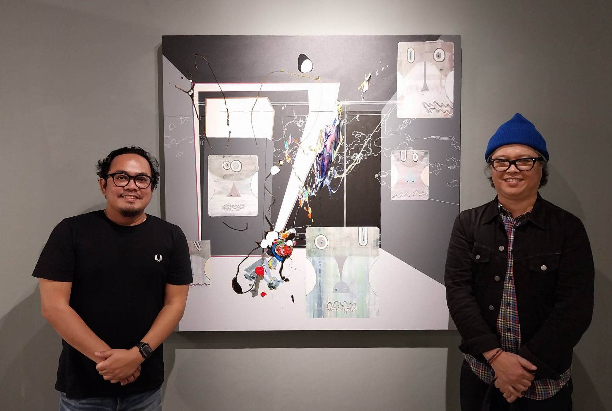 The two artists in front of a collaboration of theirs.