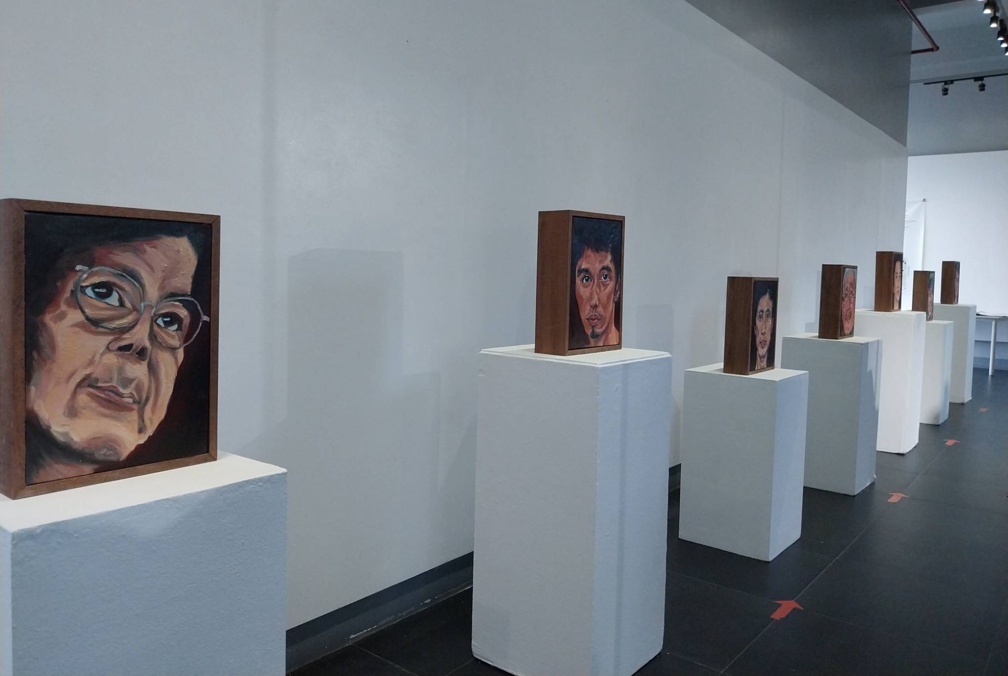 Row of portraits memorializing the dead in Mark Sanchez's 
